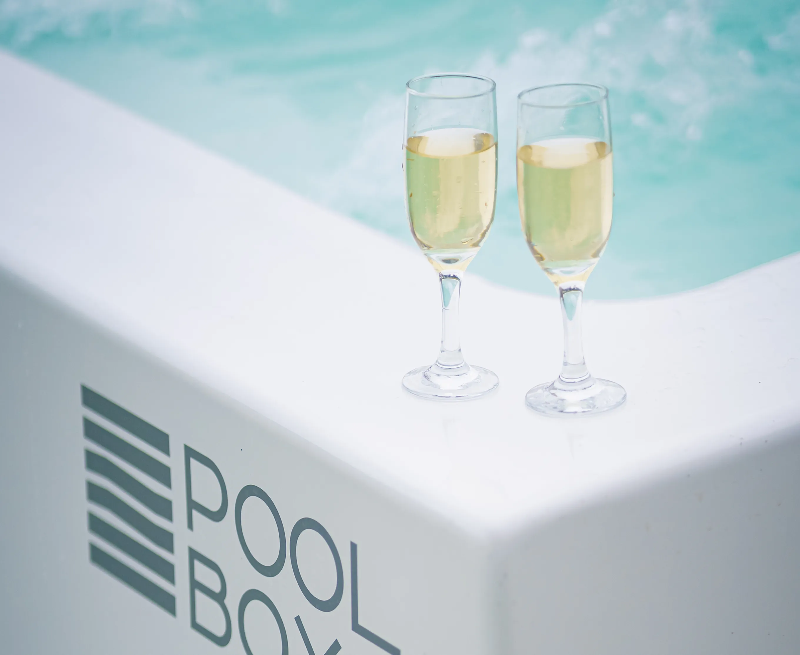 Copas de champagne sobre el borde de una Poolbox